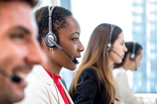 African American woman telemarketing customer service staff working with diverse team in call center office